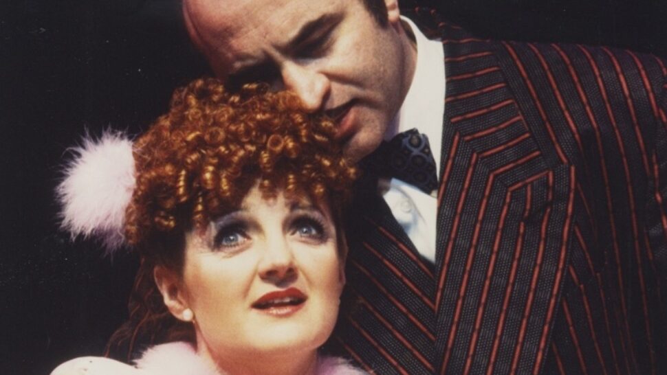 //assets.playbill.com/editorial/278e600c37936a087a328d820409d5a8-guys-and-dolls-julia-mckenzie-as-miss-adelaidebob-hoskins-as-nathan-photo-john-haynes-1676285511.jpg