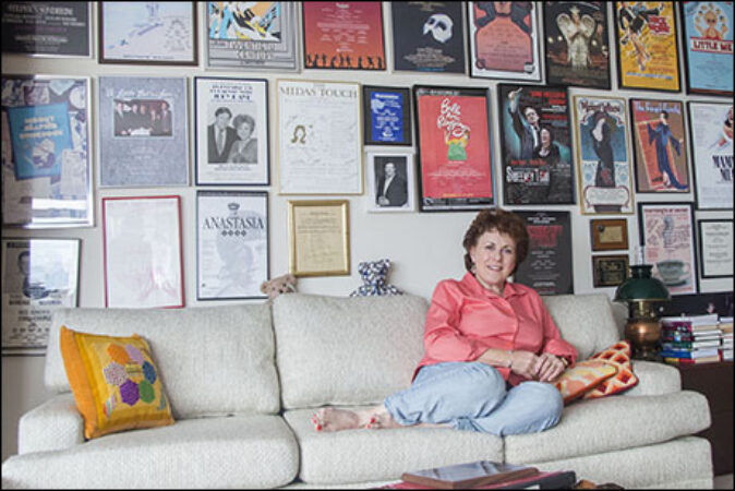 Kaye sits in front of some of her show posters